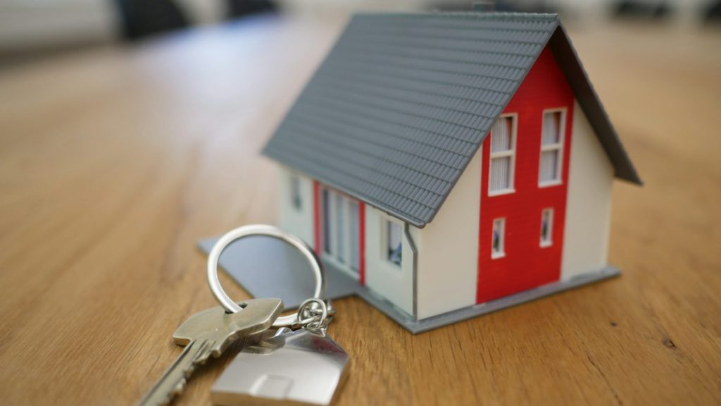 Real estate SEO services – agent handing over house keys to buyers who found the listing online